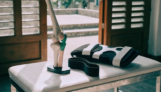 People-free sports-medicine still life with anatomical models, imaging and rehabilitation equipment illustrating Patellar (Kneecap) Dislocation: Why It Recurs and How to Stop It