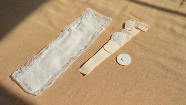 A longer surgical dressing and small keyhole dressings arranged side by side to compare open and arthroscopic shoulder surgery