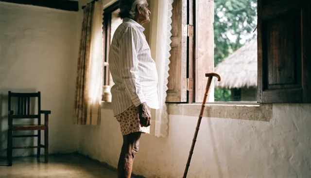 Single patient seated during hip replacement recovery beside a hip implant model and clinical imaging
